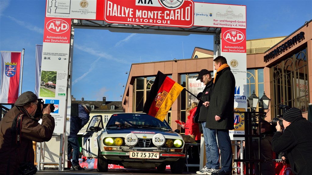 Bad Homburgs borgmester Alexander Hetjes (til højre) sender danskerne Jens Gandrup Jørgensen (Odense) og Kristian Flensbak Jørgensen (Aarhus) ud på det 2.600 kilometer lange Rallye Monte-Carlo Historique i deres Alfa Romeo Alfetta GTV fra 1977
(Foto: Michael Eisenberg)